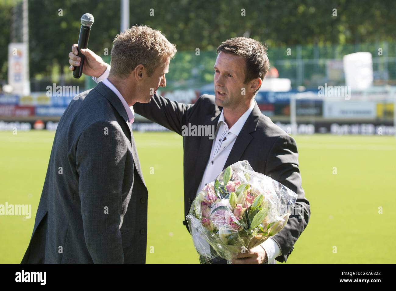 Outgoing manager of Stromsgodset FK and incoming manager of Scottish Premiership club Celtic Ronny Deila (R) is given flowers by Director of Football in Stromsgodset, Jostein Flo after half time of the match between Deila`s former club Stromsgodset and Haugesund in the Norwegian top football league in Drammen, 9 June 2014. Photo by Audun Braastad, NTB scanpix Stock Photo
